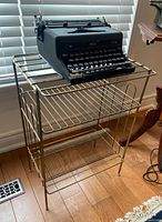 Front view of gold-tone metal record holder stand with three levels