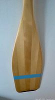 Close-up of blade showing laminated wood strips and blue stripe