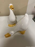 Front view of both goose figurines showing poses and coloration