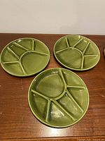three avocado green divided plates on table
