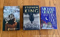 Front covers of all three hardcover novels with dust jackets displayed
