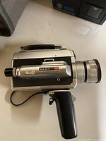 Left side view of Elmo Super 106 film camera showing lens, body and grip