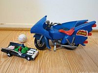 Batcycle and Batmobile side by side on floor