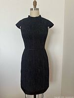 Full front view of black cap sleeve dress on mannequin