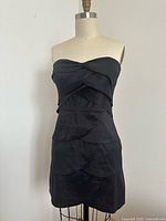 Front view of strapless layered black dress on dress form