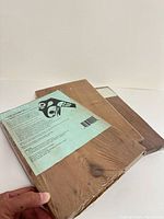 Front view of three cedar planks, two wrapped, one unwrapped