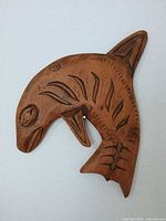 Full view of carved killer whale plaque on wall