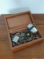Overview of open wooden box with assorted items inside