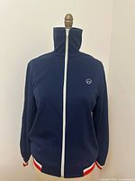 Front view of navy warm-up jacket on dress form showing overall design
