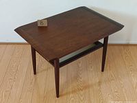 Oblique view of teak end table showing top and shelf
