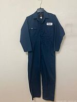 Full view of navy blue coveralls hanging on hanger