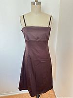 Front view of chocolate brown satin midi dress on dress form