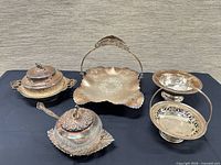Five silver-plate pieces grouped on table