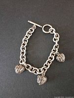 Full view of sterling silver bracelet with three heart charms