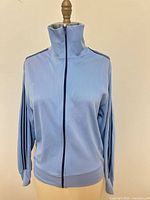 Front view zipped, collar up showing stripes and zipper