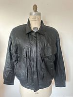 Front view of black leather jacket on mannequin