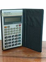 Calculator open in folding case showing keypad and display