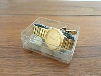 watch and cufflinks inside clear plastic box