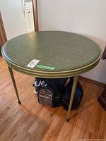 Overall view of round green vinyl folding table