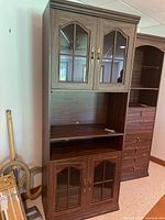 Full view of cabinet showing upper glass doors, open center shelf, lower glass doors