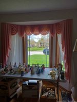 Full bay window showing pink valance, side drapes and white sheers
