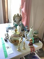 Overview of lot on table showing candy dish, candle holders, figurines, cow bank