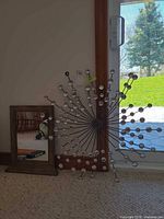 Mirror and starburst wall art leaning against wall