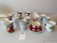 Group shot of 18 mugs showing variety of patterns and two lids