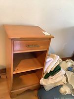 Front view showing drawer, two shelves, wood finish