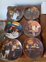 All six Norman Rockwell plates displayed face up to show artwork and rims
