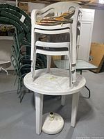 overall view of stacked chairs on table with umbrella base beneath