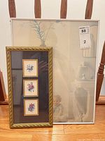 Both framed prints standing together showing size contrast and frames
