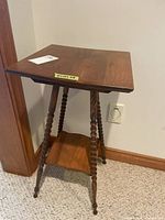 Full view of wooden fern table showing square top, spindle legs, lower shelf