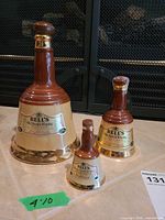 Three sizes of Bell's ceramic whisky decanters front view