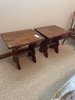 Pair of matching pine side tables against wall