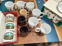 Group view showing multiple souvenir, Baileys and polo scene mugs in boxes