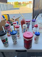All 13 vintage plastic drink containers arranged on table