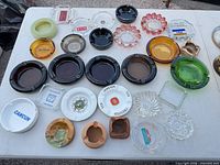 Overall view of twenty assorted ashtrays laid out on table