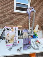 Entire vacuum with hose, accessories, and box on table