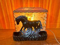Front view of illuminated ceramic horse TV lamp with fiberglass shade