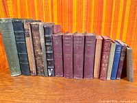 Entire row of sixteen assorted antique hardcover books