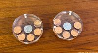 Two round lucite coin paperweights top view