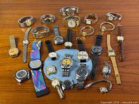 Top view of entire lot showing all wristwatches arranged on wooden surface