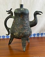 Full view of bronze tripod ewer showing dragon handle, bird spout, lid