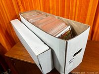 Long white comic long box and short box filled with bagged comics