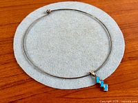Entire choker necklace and pendant on felt pad