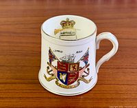 Front view of mug showing heraldic shield, flags, ship, and date 1893