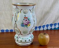 Front view of vase beside apple for scale