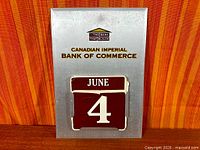 Front view of CIBC metal perpetual calendar showing month and date cards