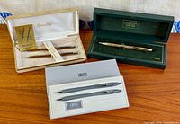 Overview of three open pen cases displaying all five writing instruments